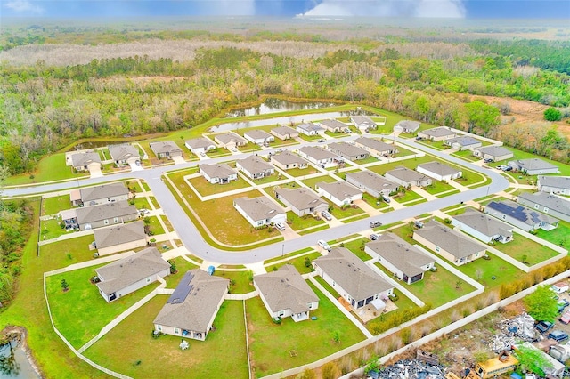 aerial view with a residential view, a view of trees, and a water view