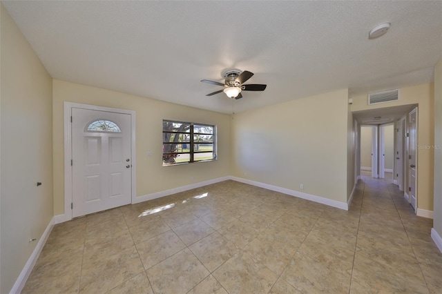 entryway featuring light tile patterned floors, baseboards, visible vents, and ceiling fan