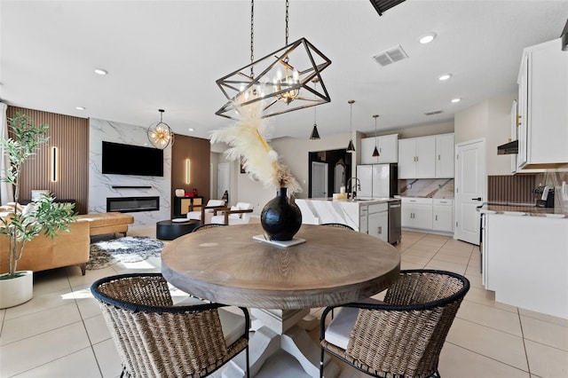 dining space featuring light tile patterned floors, visible vents, a premium fireplace, and recessed lighting