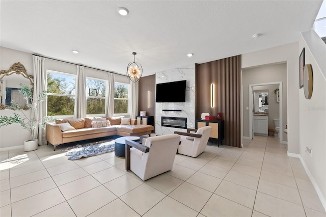 living room with an accent wall, light tile patterned floors, recessed lighting, and a premium fireplace