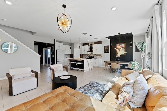 living room with recessed lighting, baseboards, an inviting chandelier, and light tile patterned flooring