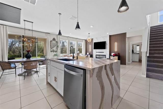 kitchen featuring a sink, light stone countertops, dishwasher, and light tile patterned floors