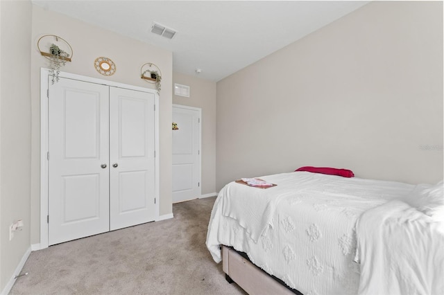 carpeted bedroom featuring a closet, visible vents, and baseboards