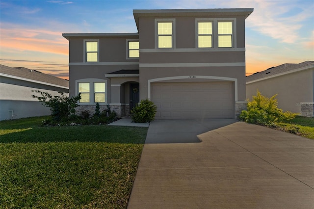 view of front of home featuring a front yard, stone siding, driveway, and stucco siding