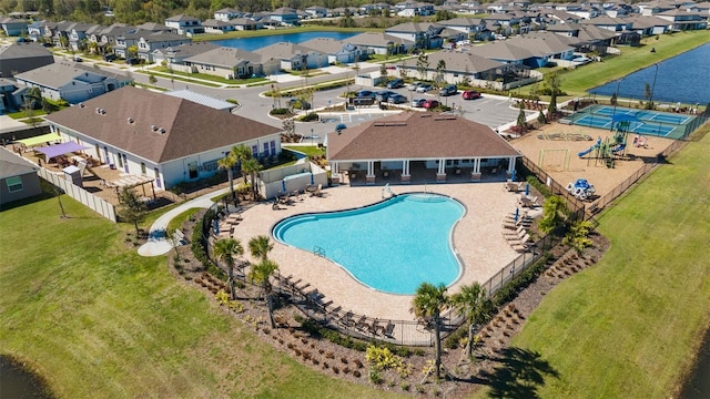 community pool with a yard, a fenced backyard, a water view, a patio area, and a residential view