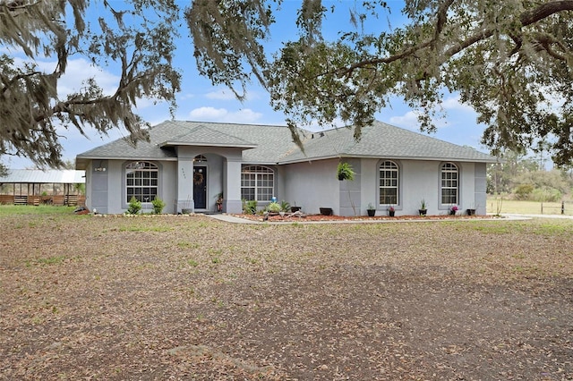 single story home featuring stucco siding and a shingled roof