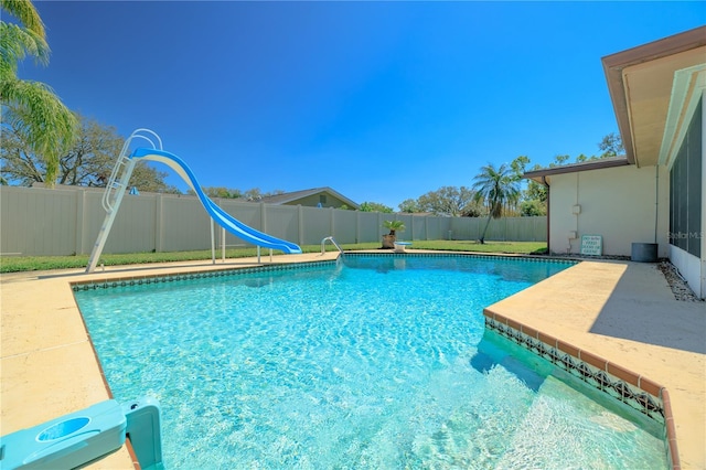 view of swimming pool featuring a fenced in pool, a fenced backyard, and a water slide