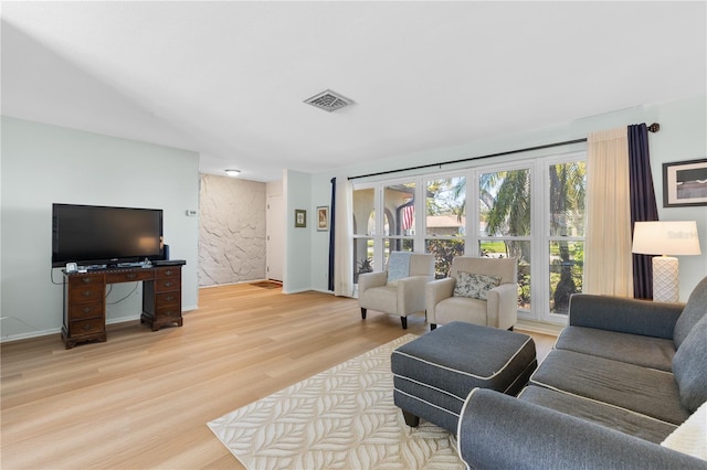 living room featuring baseboards, visible vents, and light wood-type flooring