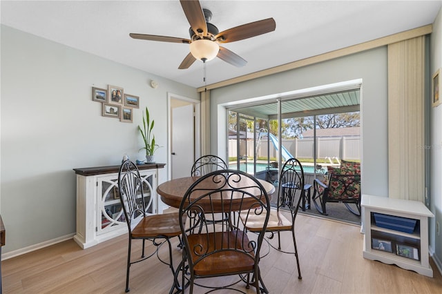 dining area with light wood-type flooring, baseboards, and a ceiling fan