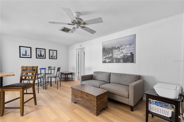 living room with visible vents, light wood-style flooring, and ceiling fan