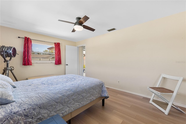 bedroom with visible vents, ceiling fan, baseboards, and wood finished floors