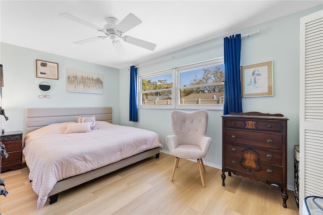 bedroom featuring light wood-type flooring, a closet, baseboards, and a ceiling fan