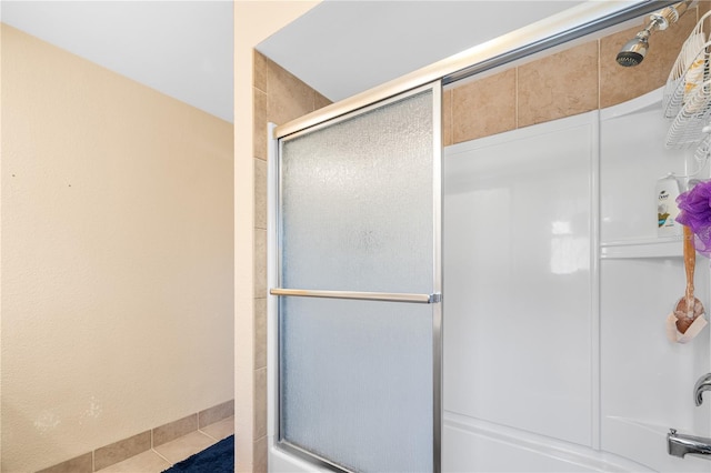 full bathroom featuring tile patterned flooring and shower / bath combination with glass door