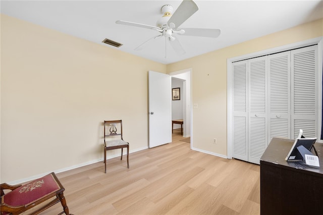 living area with light wood finished floors, visible vents, baseboards, and ceiling fan