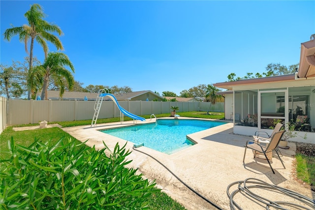 view of pool with a patio, a fenced in pool, a water slide, a fenced backyard, and a sunroom