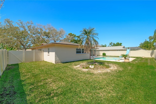 view of yard featuring a patio area, a fenced in pool, a fenced backyard, and a gate