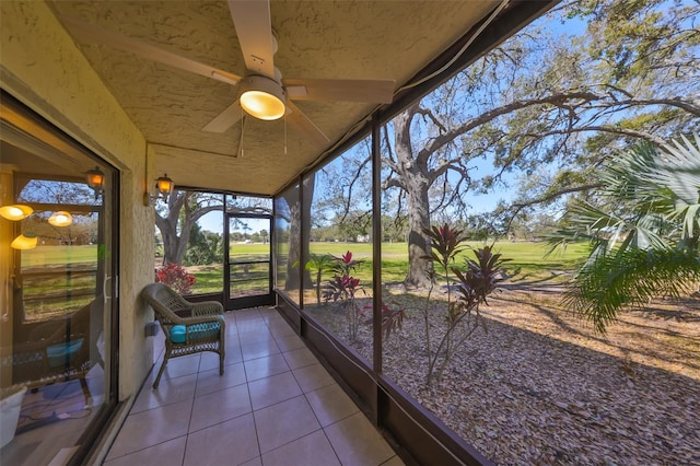 unfurnished sunroom with ceiling fan