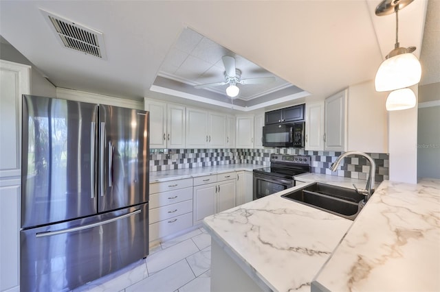 kitchen featuring visible vents, a tray ceiling, freestanding refrigerator, electric range oven, and black microwave