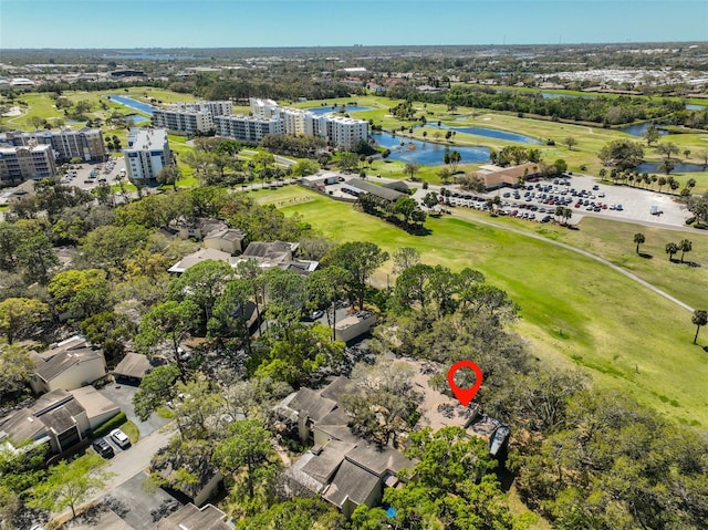 drone / aerial view with view of golf course and a water view