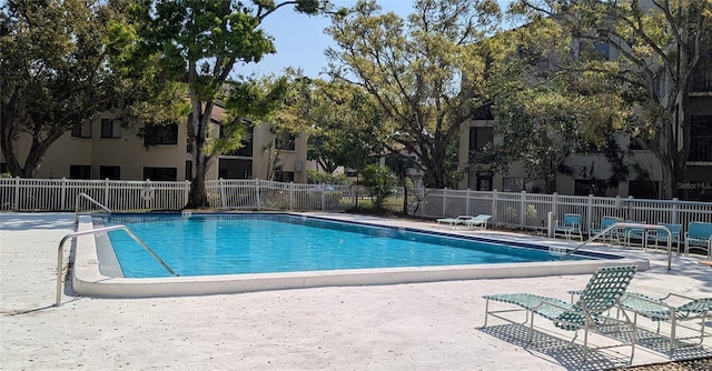 pool with a patio area and fence