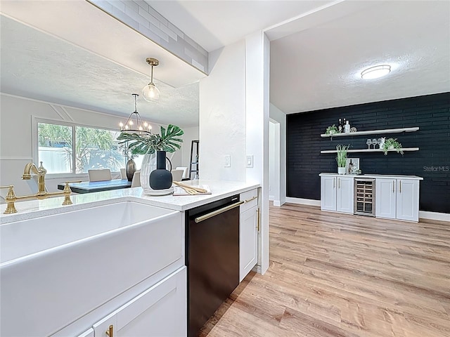 kitchen featuring white cabinetry, light wood finished floors, wine cooler, a textured ceiling, and dishwasher