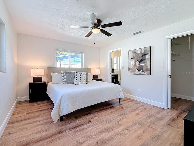 bedroom featuring light wood-type flooring, a textured ceiling, and visible vents