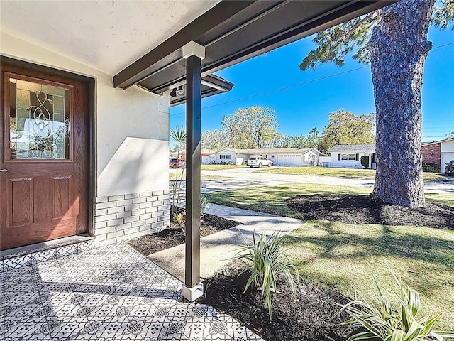 exterior space with stucco siding and a lawn