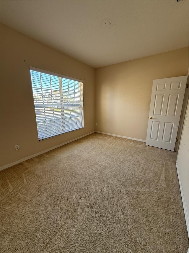 carpeted empty room with baseboards