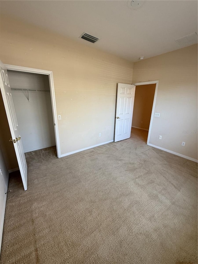 unfurnished bedroom featuring carpet, visible vents, a closet, and baseboards