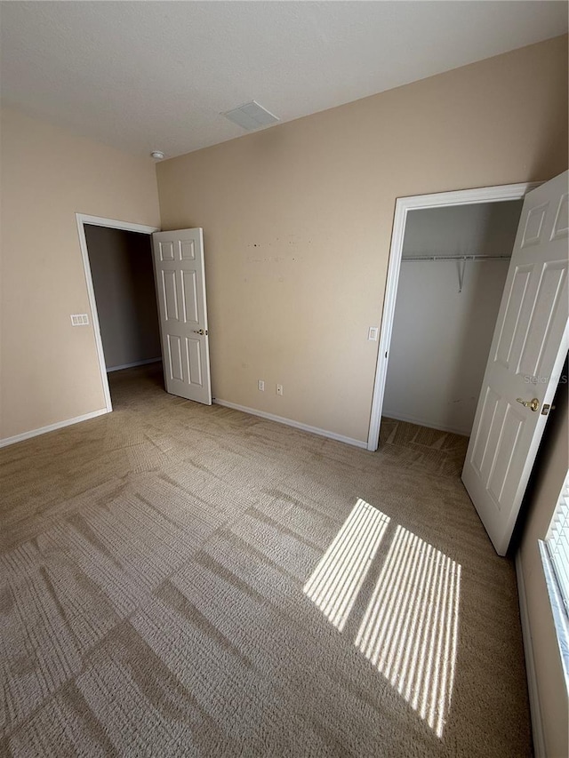 unfurnished bedroom with a closet, baseboards, and carpet floors