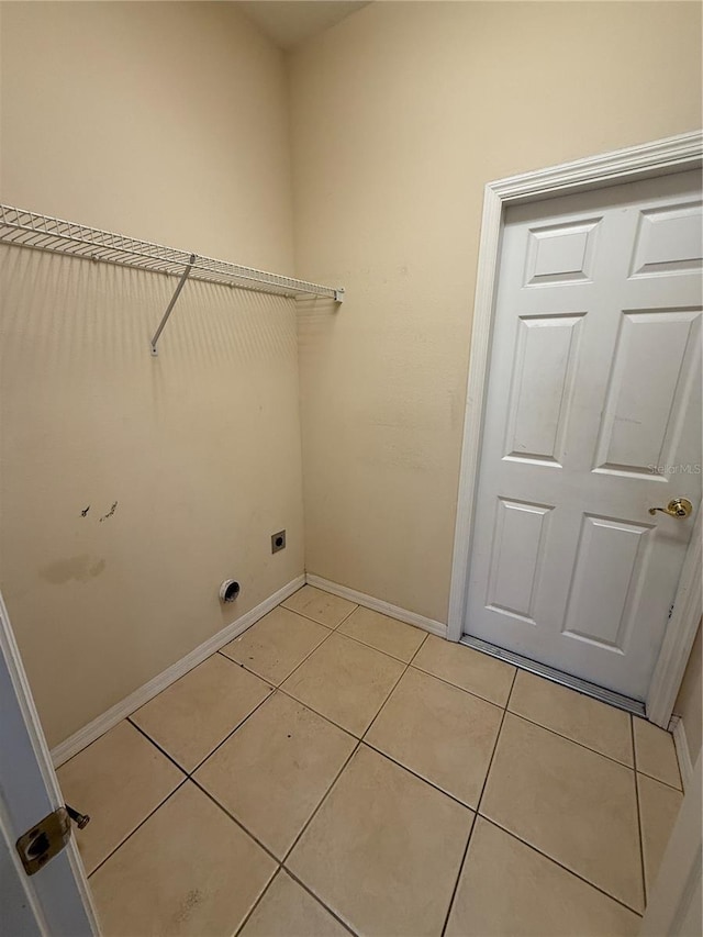 washroom featuring light tile patterned floors, laundry area, hookup for an electric dryer, and baseboards