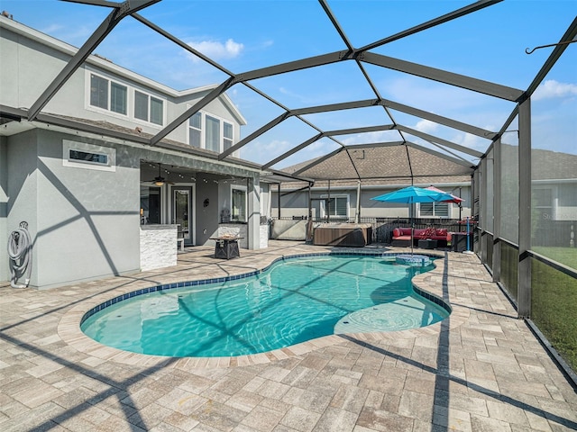 outdoor pool with a patio, a lanai, and a hot tub