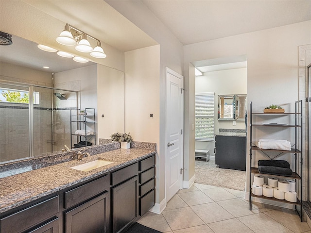 full bathroom with baseboards, a stall shower, vanity, and tile patterned flooring