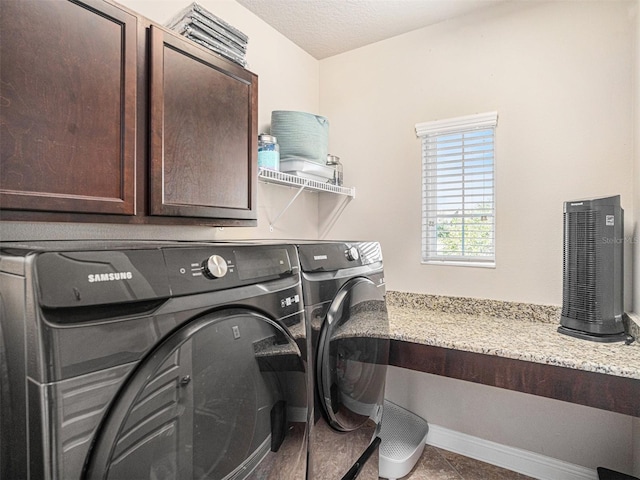 laundry area featuring tile patterned floors, independent washer and dryer, a textured ceiling, cabinet space, and baseboards