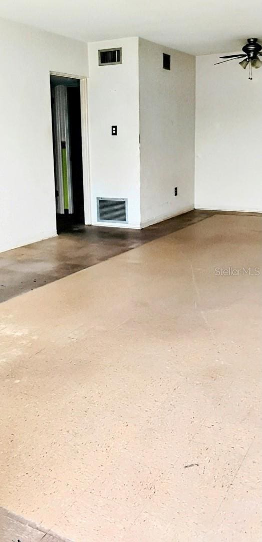 empty room featuring visible vents and a ceiling fan