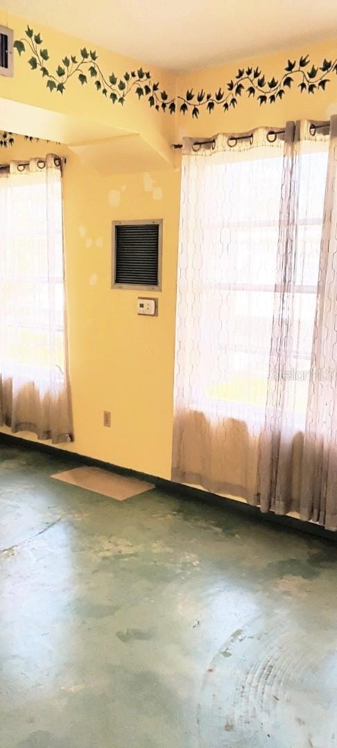 spare room featuring visible vents and concrete floors