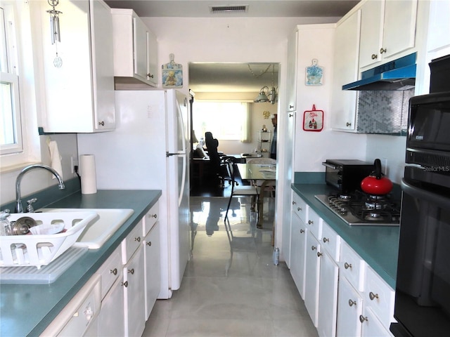 kitchen with visible vents, stainless steel gas cooktop, under cabinet range hood, white cabinetry, and dark countertops