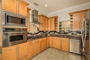 kitchen with open shelves, ornamental molding, appliances with stainless steel finishes, dark countertops, and wall chimney exhaust hood