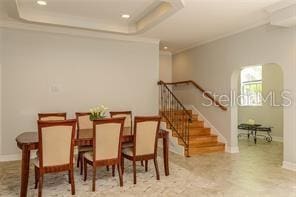 dining space featuring a raised ceiling, ornamental molding, recessed lighting, baseboards, and stairs