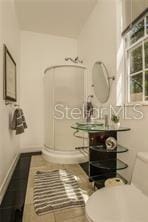 bathroom featuring tile patterned floors, baseboards, and toilet