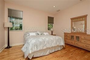 bedroom featuring vaulted ceiling, wood finished floors, and baseboards