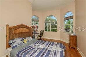 bedroom featuring baseboards and wood finished floors