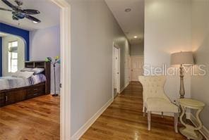 hallway with wood finished floors and baseboards