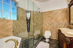 bathroom with a garden tub, toilet, a stall shower, tile walls, and vanity