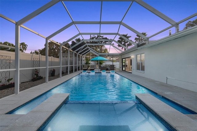 pool at dusk with a lanai, a fenced in pool, a patio, and fence