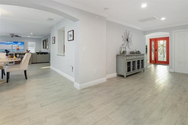 interior space with light wood finished floors, recessed lighting, arched walkways, and crown molding