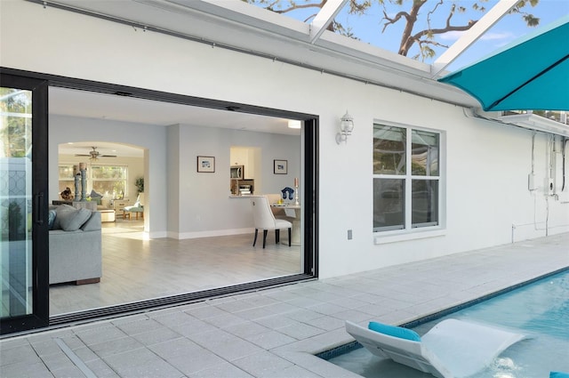 view of patio with an outdoor pool and glass enclosure