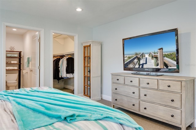 bedroom with a spacious closet, baseboards, carpet floors, recessed lighting, and ensuite bath