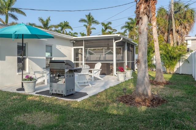 back of house with fence, a yard, a sunroom, stucco siding, and a patio area