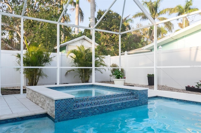 view of swimming pool featuring glass enclosure, a pool with connected hot tub, and a fenced backyard